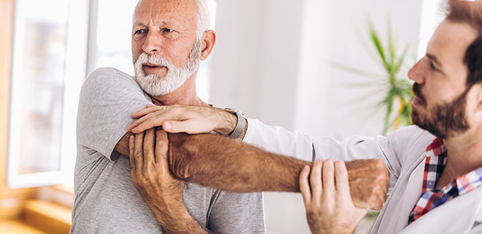 Elderly man receiving shoulder adjustment from Brentwood chiropractor