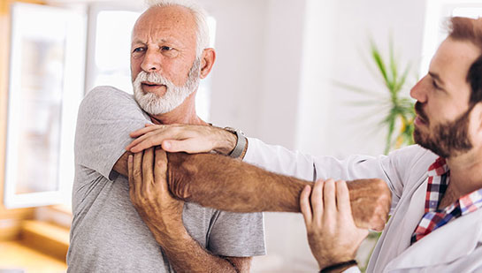 Elderly man receiving shoulder adjustment from Brentwood chiropractor